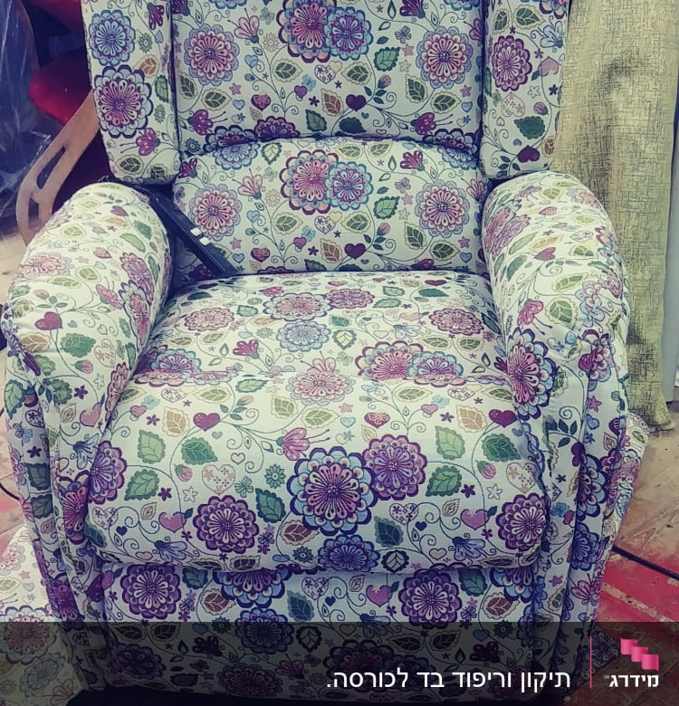 כורסה מרופדת בפרחים צבעוניים על רקע בהיר